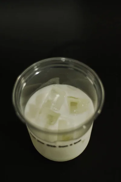 Leche Cubitos Hielo Vaso Plástico Sobre Fondo Negro —  Fotos de Stock