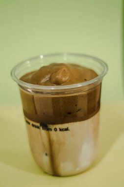 Plastik bardakta buzlu latte kahve, bardakta krema.