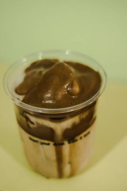 Plastik bardakta buzlu latte kahve, bardakta krema.