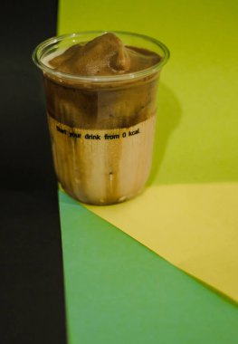 Plastik bardakta buzlu latte kahve, bardakta krema.