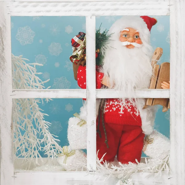 Santa Claus muñeca de pie detrás de una ventana — Foto de Stock