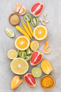Dilimlenmiş limon ve diğer meyveler gri masada