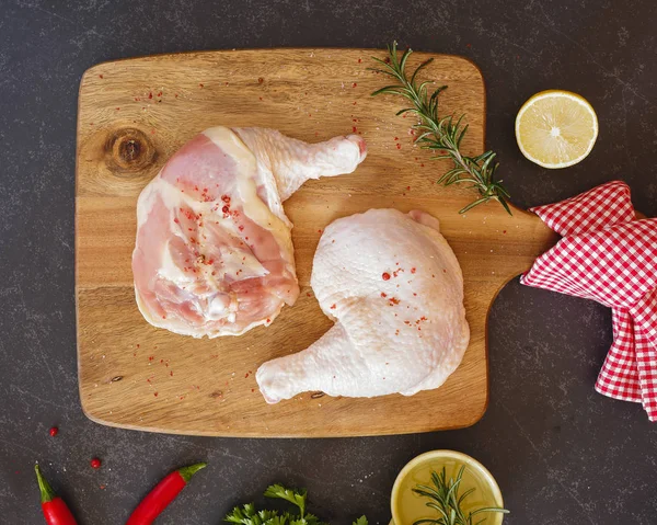 Raw chicken legs and thighs on a chopping board — Stock Photo, Image