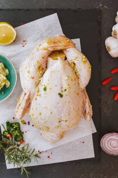 Pollo crudo entero condimentado con mantequilla y hierbas —  Fotos de Stock