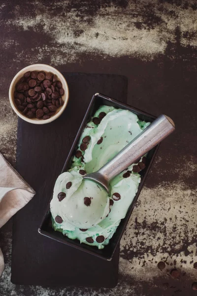 Green tea  ice cream in a metal tray with scoop and dark chocolate chips — Stock Photo, Image