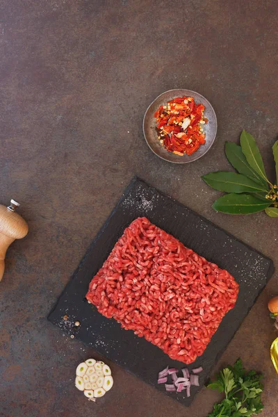 Carne fresca macinata e condimenti su fondo rustico — Foto Stock