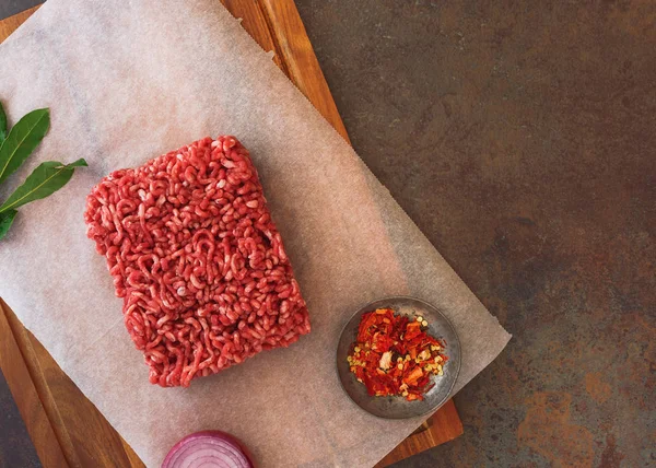 Färsk köttfärs och kryddor på slaktare papper — Stockfoto