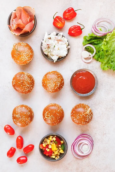 Mini bollos de hamburguesa caseros cubiertos con semillas de sésamo y varios rellenos — Foto de Stock