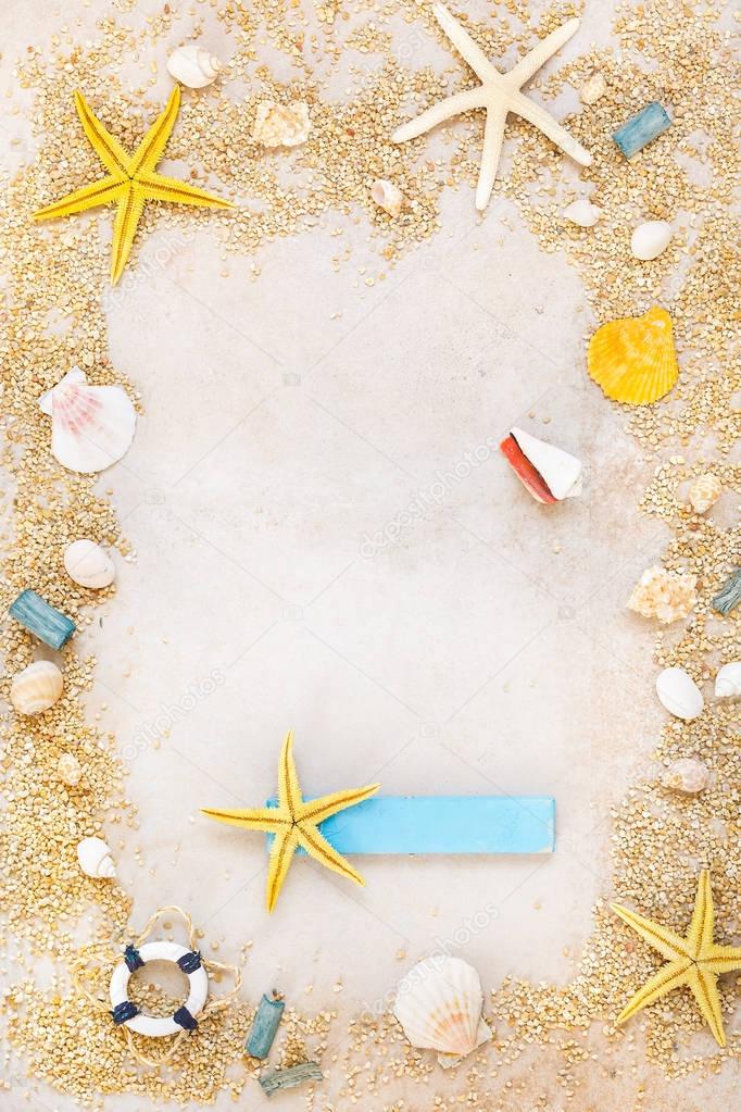 Shells and starfishes on sand background with place for text