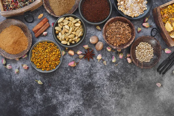 各種インド乾燥スパイスと素朴な背景に散在の乾燥花びらの鉢にナッツ 上面ビュー 空白スペース — ストック写真