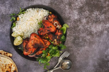 Yapışkan tandoori tavuk kanadı pilav pirinç, limon dilimleri ve Salantro ile servis baharatlı. Üstten Görünüm, boş yer