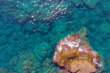 Sakin turkuaz deniz suyu ve kayaların manzaralı insansız hava aracı görüntüsü. Deniz dalgalarının ve muhteşem Rocky sahillerinin havadan görünüşü