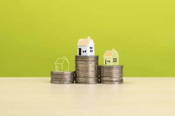 saving money to buy a house concept, house model and outline drawing on stack coins