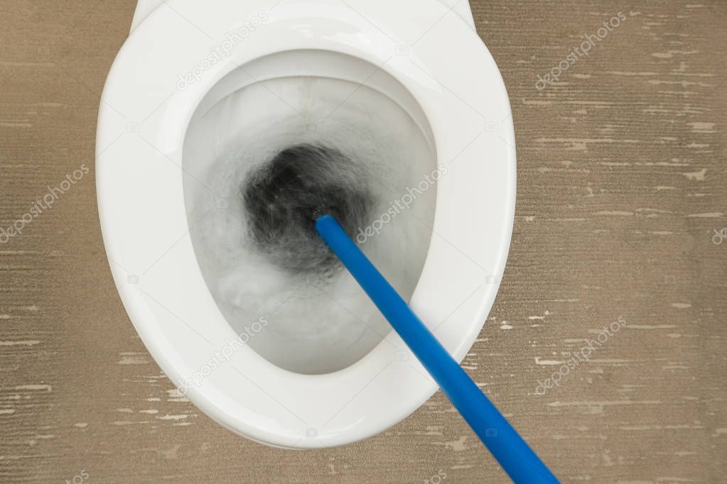 using the rubber plunger to unclog the flush toilet