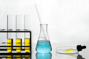 Laboratuvar sahne, sarı sıvı test tüpleri ve Damlalık, mavi sıvı şişesi içinde.