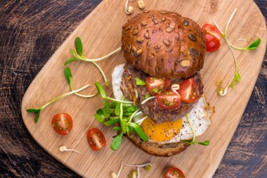 Kiraz domatesli hamburger, yeşil filiz ve sahanda yumurta.