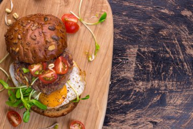 Kiraz domatesli hamburger, yeşil filiz ve sahanda yumurta.