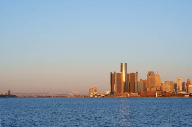 Downtown Detroit view from Belle-Isle during sunrise with view on Bridge to Windsor, Ontario, Canada.                                clipart