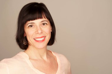  Stüdyo gülümseyen bir kumral 40 kadın portresi. Gri arka plan.                                                   