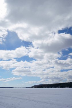  Güzel bir gün boyunca ilkbaharda gölüzerinde beyaz bulutlar ile büyük mavi gökyüzü.                                                         