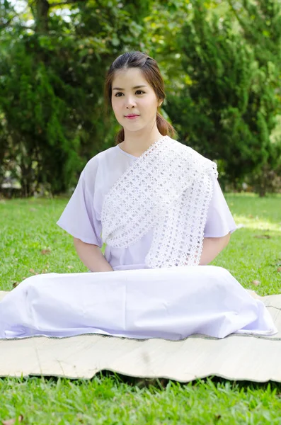 Buddhistische thailändische Frau glücklich mit weißer Kleidung, die für Meditation sitzt — Stockfoto