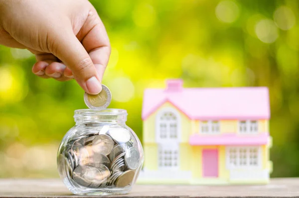 Savings money coins for house with sunlight — Stock Photo, Image