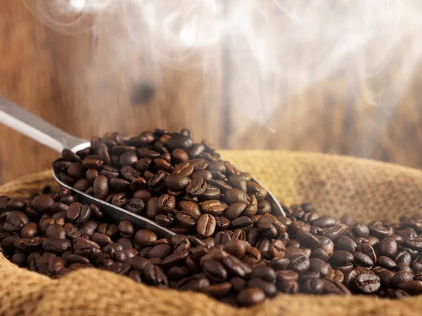 Coffee beans roasted with smoke and wood background — Stock Photo, Image