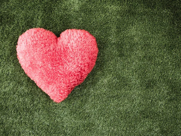 Red heart on green grass for love Stock Image