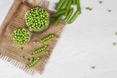 fresh green peas on a white wooden background. Top view