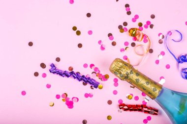 Pembe arka planda konfeti olan mavi şampanya. Moda tatil konseptini kopyalayan üst görünüm.