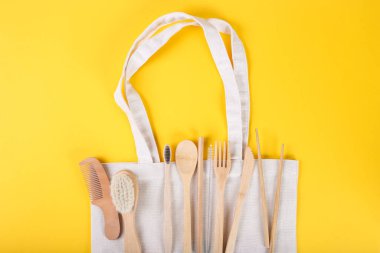 Çevre dostu bambu çatal bıçak seti sarı arka tarafta. Sürdürülebilir yaşam tarzı. Plastiksiz konsept. Üst görünüm, düz görünüm, kopyalama alanı olan maket