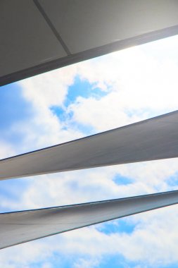 hafif bulutlu gökyüzü ve gün ışığı yansıması ile modern tente şemsiye