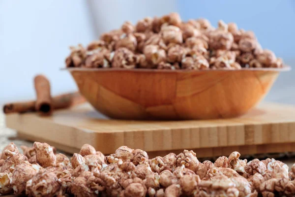 Brown chocolate flawored popcorn on the wood plate with cinnamon Stock Image