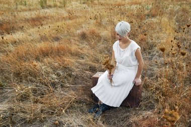 Bir buket kuru debisi tutan genç bir kadınla Vintage kavramı