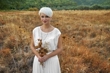 Bir buket kuru debisi tutan genç bir kadınla Vintage kavramı