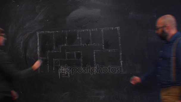 İş adamı ve iş kadını yazı tahtası üzerinde bir zemin çizim — Stok video