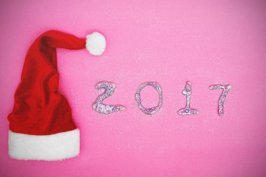 Santa Claus şapka pembe bir arka plan ve glitter yazmak 2017