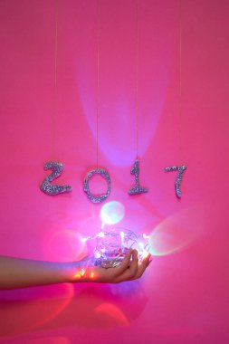 Noel ışıkları tutan glitter ve kadının el ile yapılan 2017 