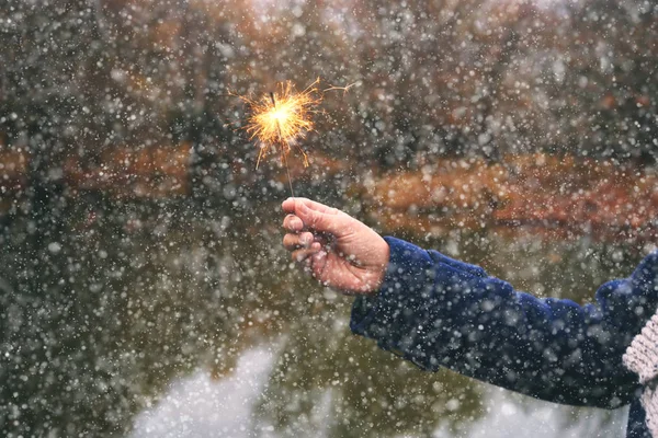 フォレストで線香花火を保持している女性冬雪の日 — ストック写真