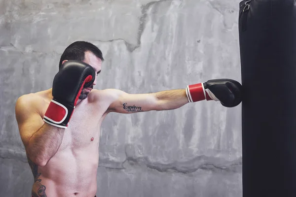 Boxeador haciendo ejercicio con saco de boxeo — Foto de Stock