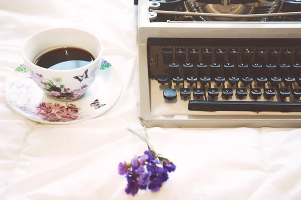 Vintage typewriter and cup of coffee on  the bed — Stock Photo, Image