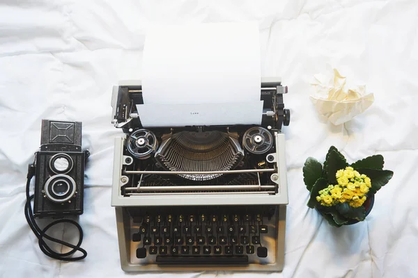 Vintage írógép és a kamera az ágyon — Stock Fotó