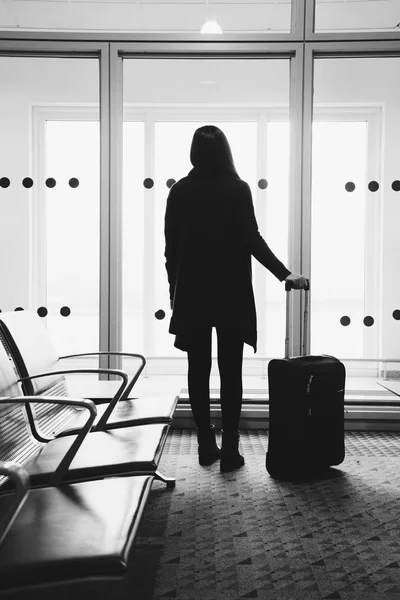 Jovencita en el aeropuerto, mirando por la ventana a los aviones —  Fotos de Stock