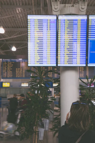 Mulher procura horário de voo no aeroporto — Fotografia de Stock