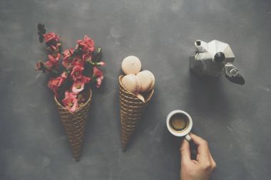 Kahve, macarons ve çiçekler dondurma koni çimento backgro üzerinde