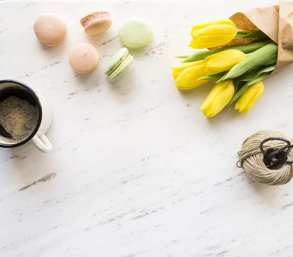 Flowers, coffee, macarons on marble background