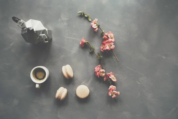 Top view of coffee, macarons and flowers on cement background — Stock Photo, Image