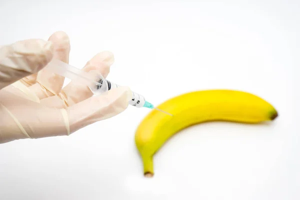 Sperimentazione OGM scienziato iniettando liquido nella banana su bianco b — Foto Stock