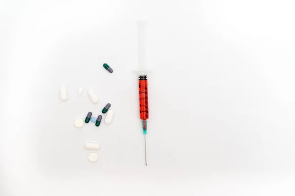 Jeringa médica y pastillas aisladas sobre fondo blanco — Foto de Stock
