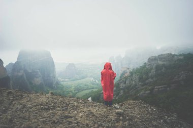 Kadın kırmızı yağmurluk ile peyzaj Meteora view sahiptir 